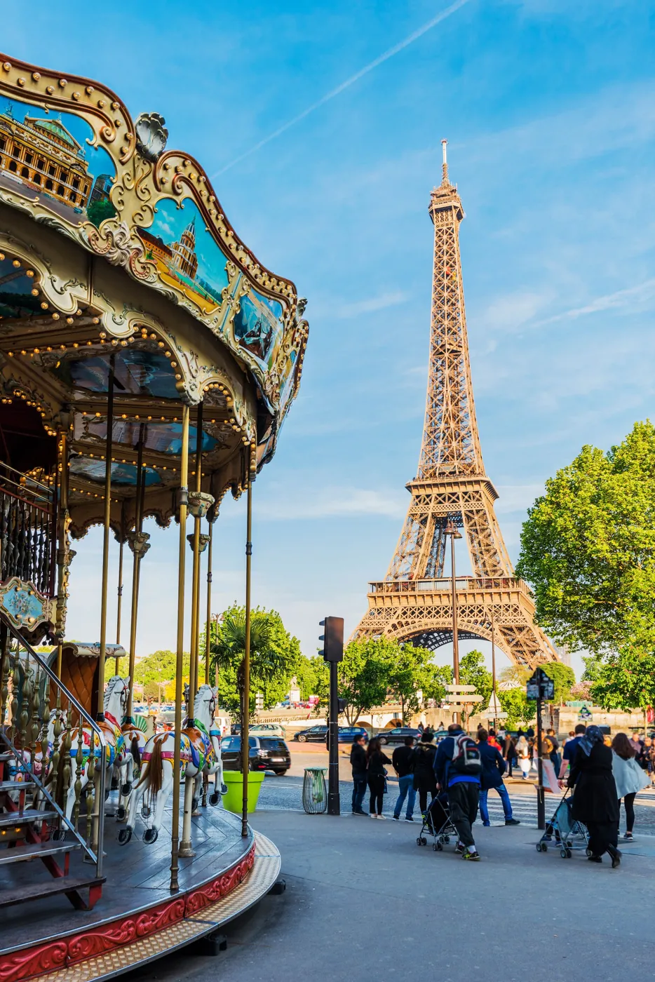 Un manège à l'ancienne devant la tour Eiffel, sous un ciel bleu de printemps